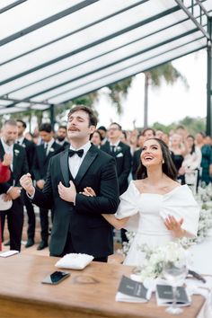 a bride and groom standing in front of an audience