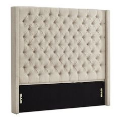 an upholstered headboard with buttons on the top and bottom panel, in beige linen