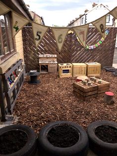 there are four tires sitting on the ground in front of some plants and other things