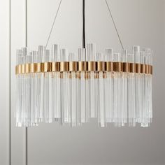 a chandelier hanging from the ceiling with gold trimmings and glass rods