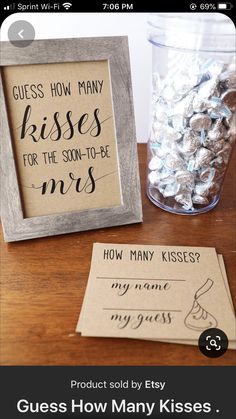 a wooden frame sitting on top of a table next to a glass filled with candy