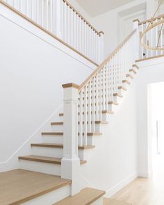 a white staircase with wooden handrails in a house