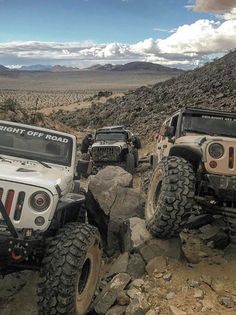 two jeeps driving on rocks in the desert