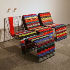 three colorful chairs sitting next to each other on the floor in front of a white wall