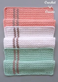 four crocheted dishcloths sitting on top of each other in different colors