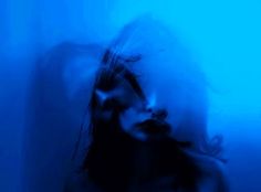 a blurry image of a woman's face and hair in the blue light