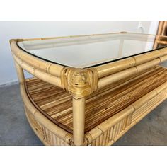 a rattan and glass coffee table in the shape of a bamboo frame with gold accents