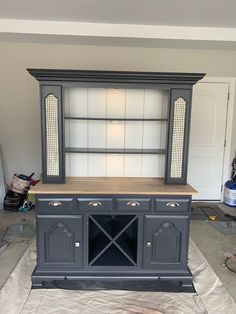 an entertainment center in the process of being painted with gray paint and silver metal hardware