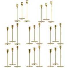 twelve brass candlesticks in different sizes and shapes, all lined up against a white background