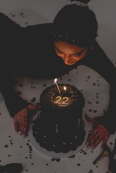 a woman is blowing out the candles on her birthday cake while wearing high heel shoes