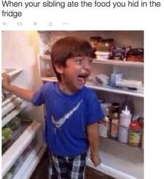 a young boy standing in front of an open refrigerator with his mouth wide open and tongue out