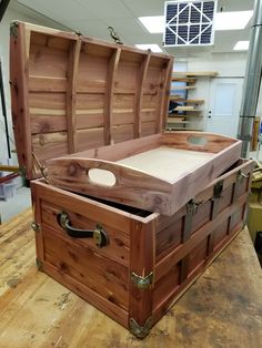 an open wooden chest sitting on top of a table next to other boxes and shelves