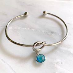 DETAILS:- Adjustable knot cuff bracelet- Bezel set crystal charm color: aquamarine- Silver or gold finish- Handmade in Miami- Nickel and lead freeSHOP THE COLLECTION:https://www.etsy.com/shop/TigerlillyCouturePACKAGING:Arrives in a custom Tigerlilly box, perfect for gifting and storing the jewelry.Printed receipts are not included in the box. You may print a receipt directly from Etsy for your records.If it is a gift, we will print your custom gift message and include it in the package.To includ Blue Aquamarine Bracelets As Gift, Aquamarine Bracelet Gift, Beaded Aquamarine Bracelet For Gift, Adjustable Silver Aquamarine Bracelet, Blue Nickel-free Crystal Bracelet For Gift, Adjustable Knot, Bracelet Knots, Knot Bracelet, Birthstone Bracelets