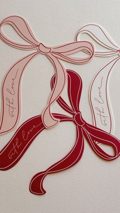 some red and white paper cut out with ribbon around it's neck, on a white surface