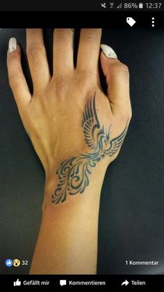 a hand with a bird tattoo on it