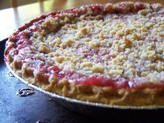 a pie sitting on top of a pan covered in crumbled toppings,