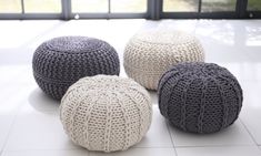 three crocheted poufles sitting on the floor in front of a window