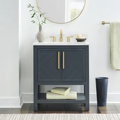 a bathroom with a sink, mirror and towels on the shelf in front of it