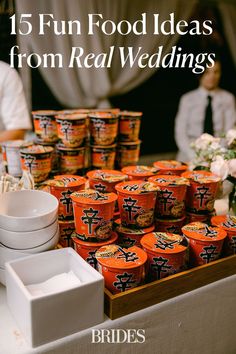 an assortment of yogurts are on display at a buffet table with people in the background