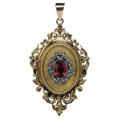 France, circa 1880s This ornate 18K gold locket pendant is designed in the Renaissance Revival style. The front is centered with a reddish orange citrine (10 x 6.7 x 4.4 mm) framed by a silver wreath embellished with rose cut diamonds. The interior is fitted with two miniature picture frames. Marked on the back cover and bezel with eagle’s head French assay mark for 750 gold standard (18K). Total length with bail is 62 mm (2 3/8 in.) Width is 34 mm (1 1/4 in.) Weight is 14.83 grams. Sold without 1600s Jewelry, Victorian Pendant Jewelry For Opera, Victorian Red Medallion Jewelry, Red Victorian Medallion Jewelry, Red Victorian Jewelry For Ceremonial Occasions, Antique Red Medallion Jewelry, Antique Red Oval Pendant Jewelry, Red Victorian Engraved Jewelry, Red Victorian Jewelry For Vintage Collection