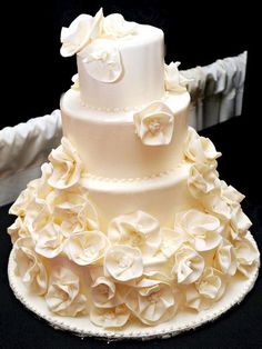 a three tiered wedding cake with white flowers