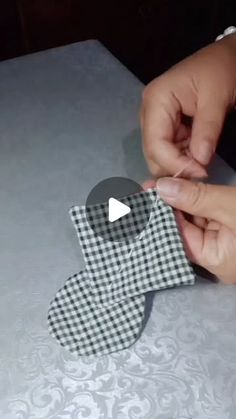 someone is making an origami man out of paper and fabric with one hand