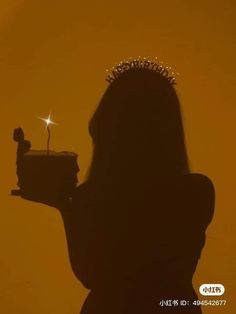 the silhouette of a woman with a tiara on her head holding a cell phone