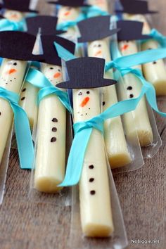 some toothpicks with hats on them are decorated like snowmen and have blue ribbons