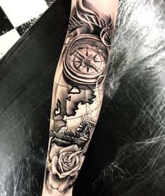 a man's arm with a compass and rose tattoo design on the left forearm