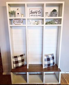 a white shelf with some black and white items on it, along with two checkered pillows