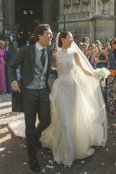 a bride and groom are walking through confetti