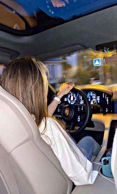 a woman driving a car while holding the steering wheel