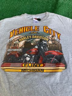 a gray shirt with an image of two motorcycles on it and the words, vehicle city