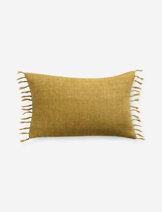 a mustard colored pillow with fringes on it