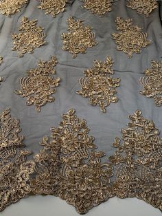 an embroidered fabric with gold and silver flowers on it