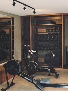 there is a stationary exercise bike in the middle of a room with shelves full of equipment