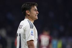 a close up of a soccer player wearing a white uniform and looking off to the side