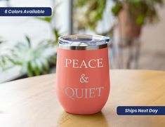 a pink tumbler sitting on top of a wooden table