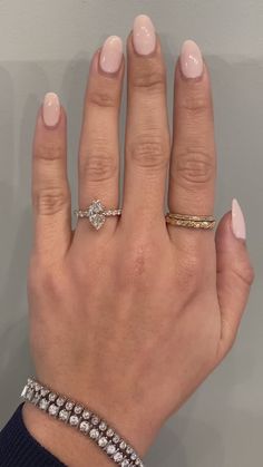 a woman's hand with two different rings on her left and the middle finger