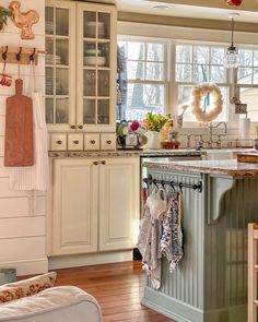 a kitchen filled with lots of white cabinets and counter top space next to a window