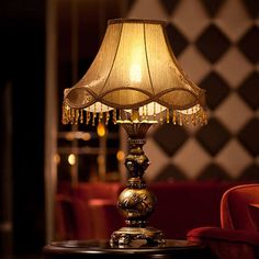 a lamp sitting on top of a table next to a red chair