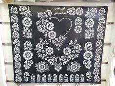 a black and white wall hanging on the side of a building with an ornate design