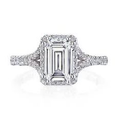 an emerald cut diamond ring with diamonds surrounding it