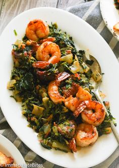 a white plate topped with shrimp and greens