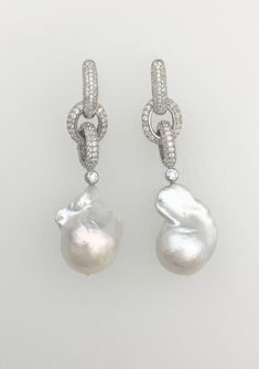 Stunning cultured freshwater Baroque pearls on an interlocking pavé rhodium plated chain.  Chain-link is available in 18K White-gold, 18K Rose-gold or 18K Yellow-gold plated over sterling silver.  PEARLS ARE 20-25mm; earrings are approx. 2 ¼" long.  Enhancer sold separately. Please note: Due to the unique and natural origin of pearls, slight variations may occur.  These characteristics enhance the beauty of the product and truly make them a one of a kind piece. Luxury Pearl Chain Sterling Silver Earrings, Elegant White Chain Earrings, Luxury Silver Earrings With Pearl Chain, Luxury Silver Pearl Chain Earrings, Luxury Pearl Chain Drop Earrings, Elegant Formal Earrings With Chain Detail, Elegant Chain Earrings For Formal Occasions, Luxury Dangle Earrings With Pearl Chain, Elegant Round Chain Earrings