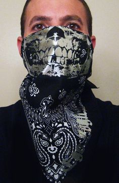 a man wearing a bandana covering his face with a skull mask on top of it