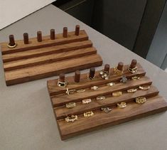 two wooden trays with rings on them sitting on a counter next to each other