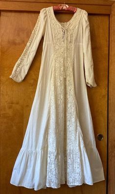 This is a vintage 1970s Gunne Sax dress, worn once as an 8th grade graduation dress in 1973 and has been in storage ever since. 100 percent cotton muslin, handwashable. Please review detailed measurements for an accurate fit. it is in good condition with several small, light spots on the bottom tier of the skirt. there is a small 2" repaired tear near the bottom and slight discoloring on the bodice tie tag size: 11 shoulders: 13" flat measure  bust: 34" waist: 28" shoulder to bottom edge of wris Vintage Long Dresses For Spring, Vintage Flowy Maxi Dress, Flowy Vintage Maxi Dress For Daywear, White Cotton Vintage Dress With Long Sleeves, White Long Sleeve Cotton Vintage Dress, White Cotton Long Sleeve Vintage Dress, White Cotton Lined Maxi Dress, 1970s Cotton Vintage Dress For Daywear, White Lined Cotton Vintage Dress