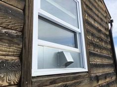 a window on the side of a wooden house