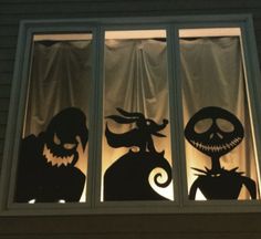 three halloween silhouettes are seen through the window